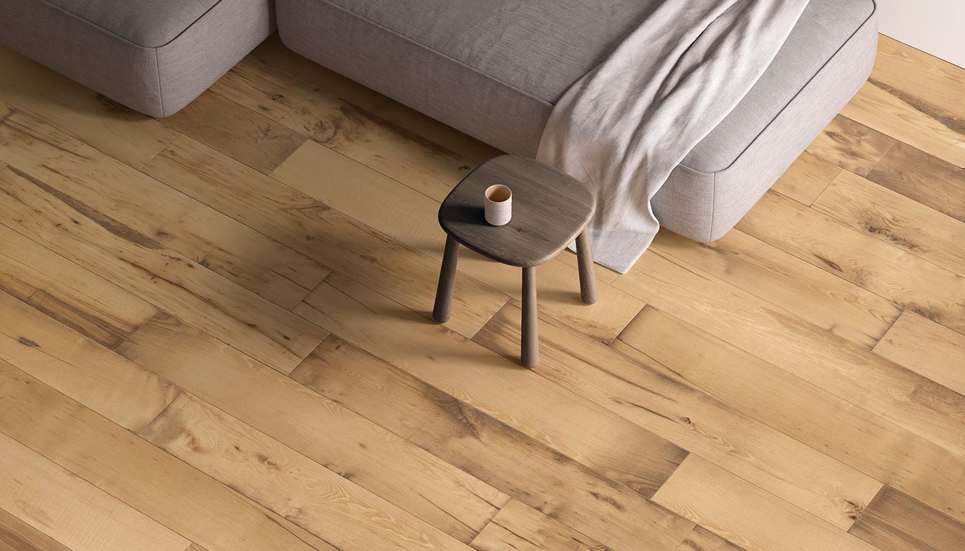 Twenty Tronco porcelain flooring showcased in a cozy living room setting with a sofa and wooden stool.