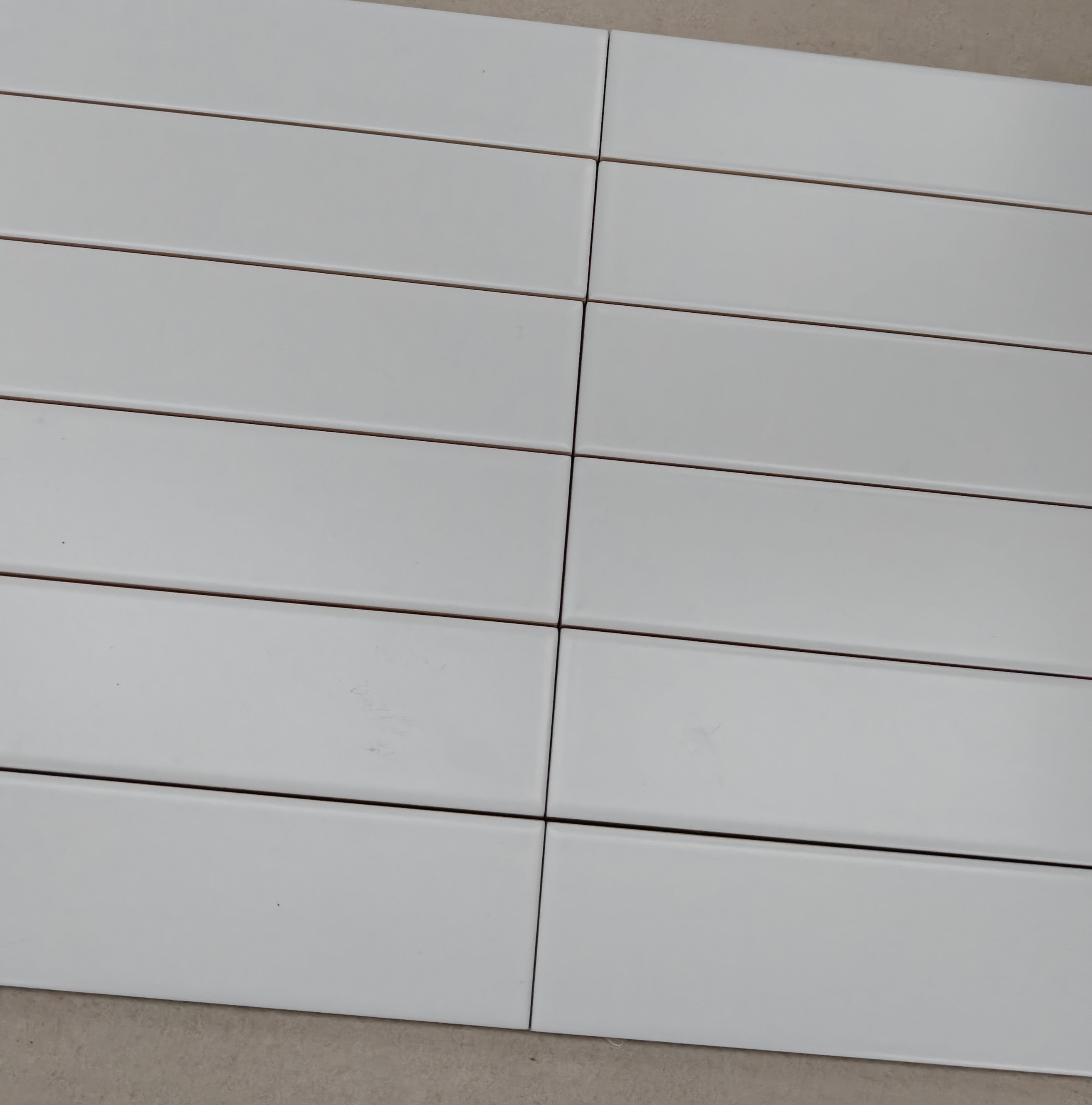 Evolution Matt Blanco ceramic wall tiles arranged in a sleek layout, showcasing their glossy white finish.