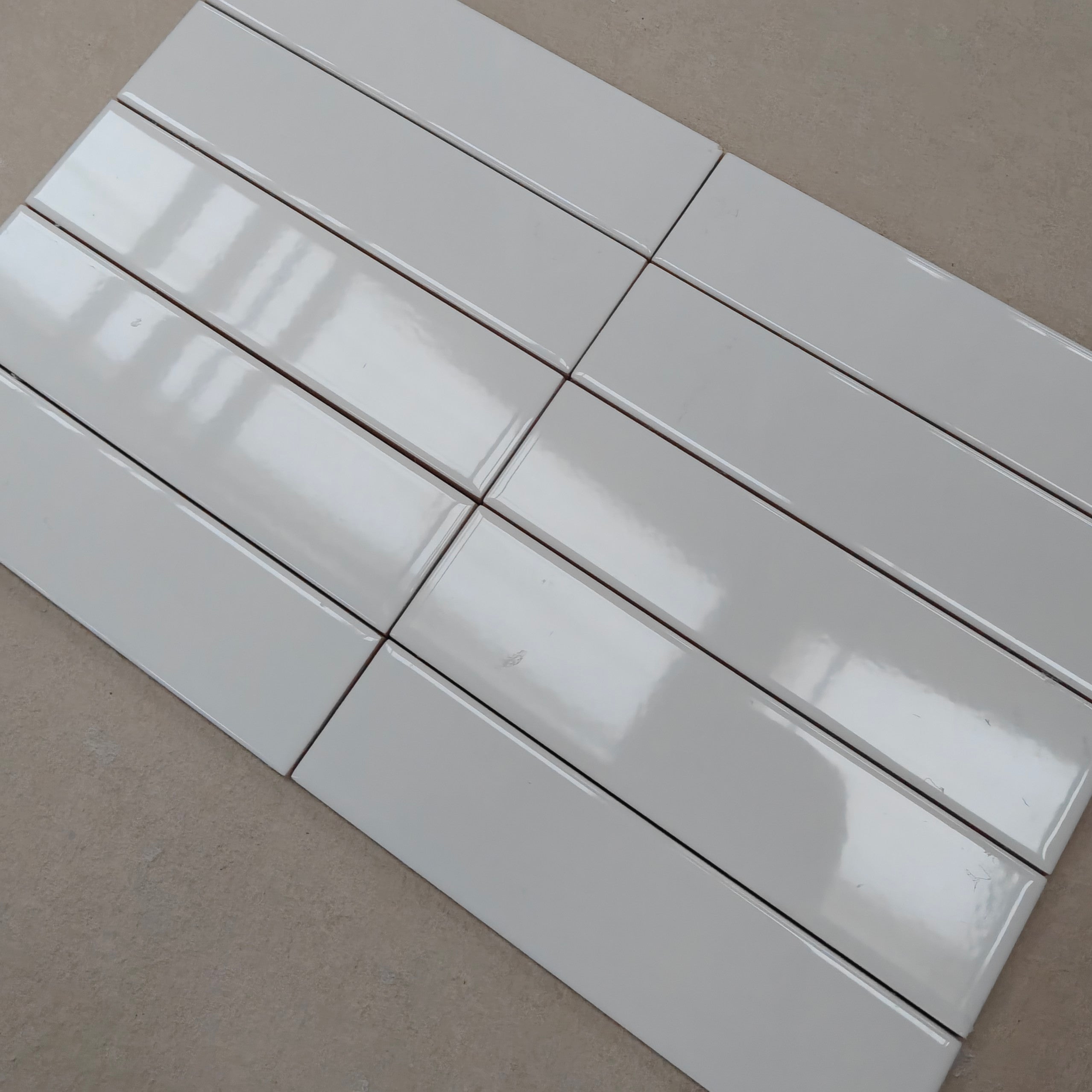 Evolution Brillo Blanco tiles arranged in a modern layout, showcasing their glossy white finish and clean design.