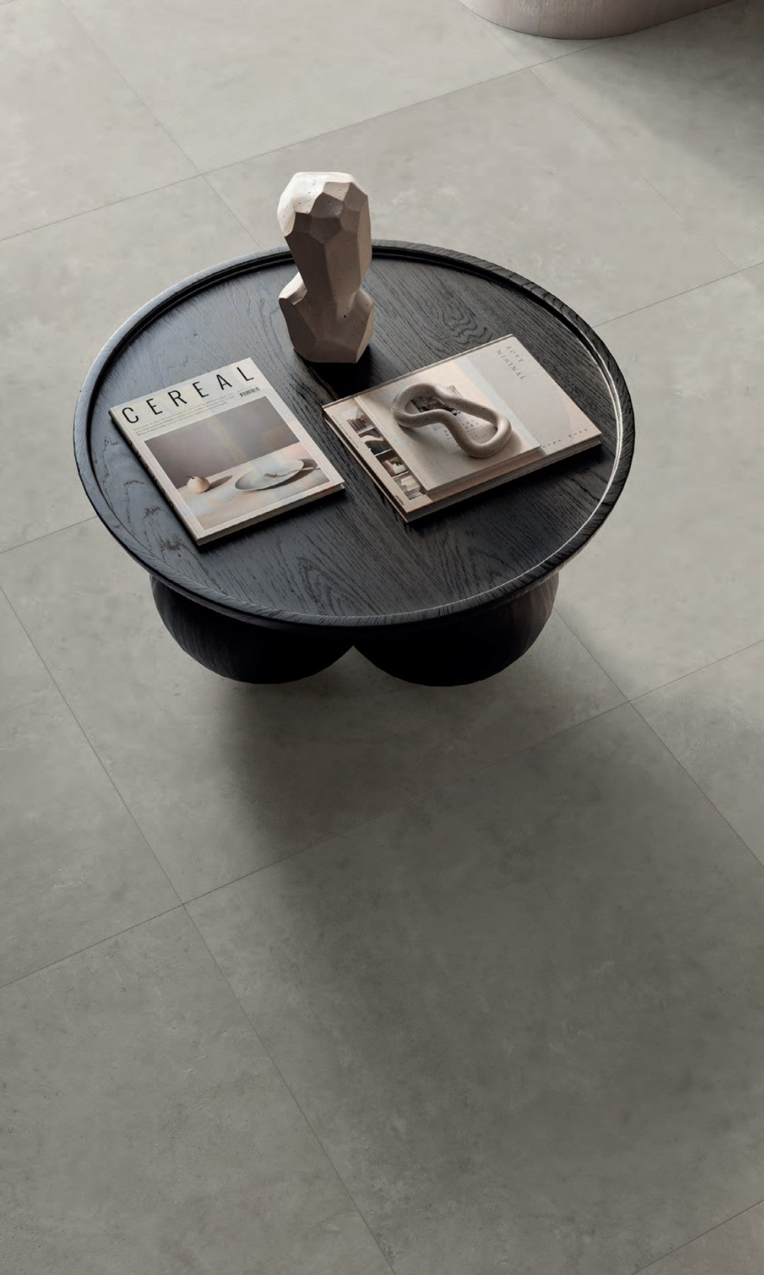 Frame Dust 80x80cm porcelain tile featured in a modern living space with a round black table and decor.