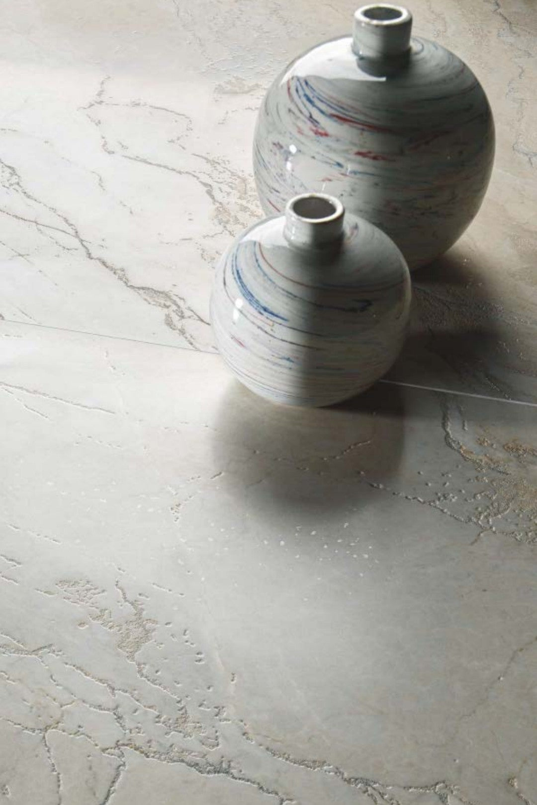 Bolgheri Stone White 60x120cm porcelain tiles with decorative vases on surface, showcasing elegant design and texture.