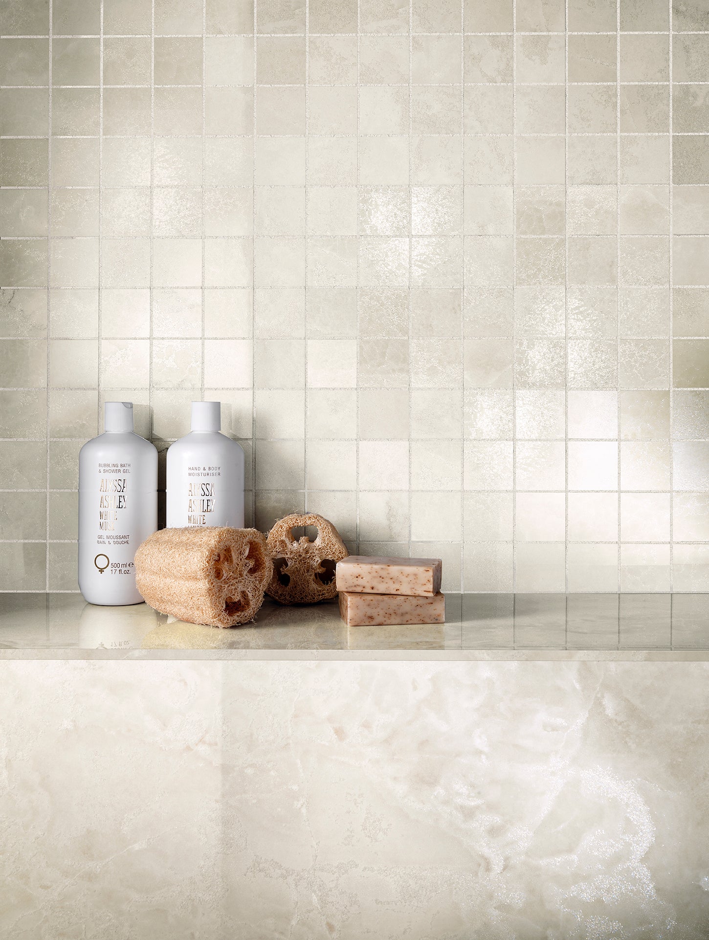 Onyx Diamond porcelain tiles displayed with shampoo bottles and natural sponges on a sleek marble surface.
