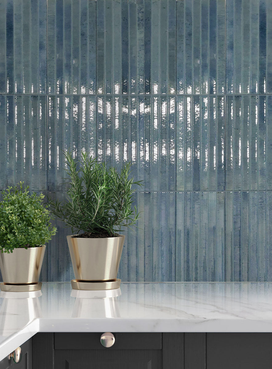 Home Sky kit kat porcelain tiles displayed in a kitchen with plants and marble countertop, showcasing serene blue-grey tones.